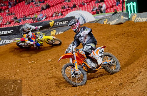 Les Smith (64) takes a turn followed by Michael Stryker (945) as they compete in a qualifying round of the Monster Energy AMA Supercross FMI World Championship at the Georgia Dome in Atlanta on Saturday, February 22, 2014. 