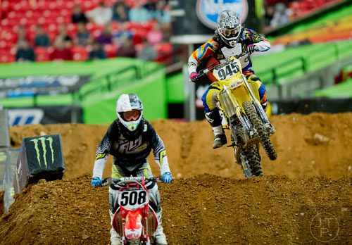 Michael Stryker (945) tries to catch Nick Click (508) as they compete in a qualifying round of the Monster Energy AMA Supercross FMI World Championship at the Georgia Dome in Atlanta on Saturday, February 22, 2014.  