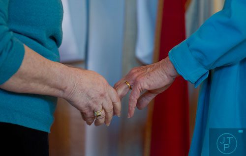 Alice Delaney (left) holds her partner MayC Brown's hand after exchanging rings during their blessing of the lifelong covenant ceremony at Holy Comforter Church in East Atlanta on Sunday, January 19, 2014. 