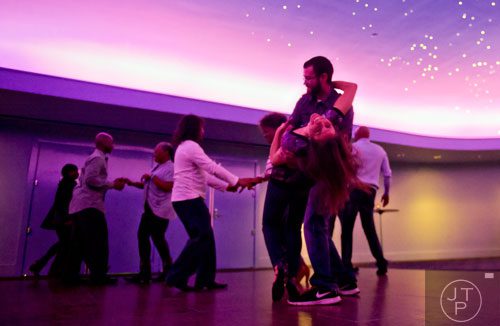 Michael Risher (right) dips Denise Larkin as they dance during Martinis & IMAX at the Fernbank Museum of Natural History in Atlanta on Friday, January 31, 2014.