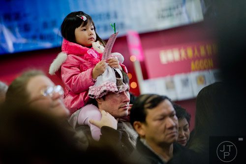 Arianna Braun (left) sits on her father Kirk's shoulders as they watch the performances during the Atlanta Chinese Lunar New Year Festival in Chamblee on Saturday, February 1, 2014. 