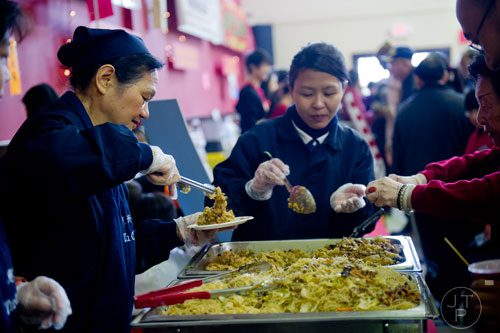 Nancy Gnug (left) and Jennifer An perpare plates of food during the Atlanta Chinese Lunar New Year Festival in Chamblee on Saturday, February 1, 2014. 