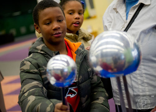 Christopher Ellis (left) uses a van de graff generator as his sister Janasha watches during the kickoff for the American Meteorological Society's 94th annual meeting at the Atlanta-Fulton Public Library in downtown on Saturday, February 1, 2014.   