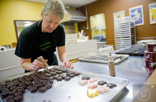 Linda Damiani puts the finishing touches on a tray of chocolate truffles at Chamberlain's Chocolate Factory in Peachtree Corners on Tuesday, February 4, 2014.   
