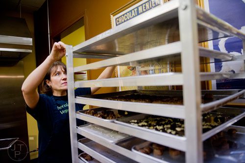 Anne Stroer places a tray of chocolates on a rack to set at Chamberlain's Chocolate Factory in Peachtree Corners on Tuesday, February 4, 2014.