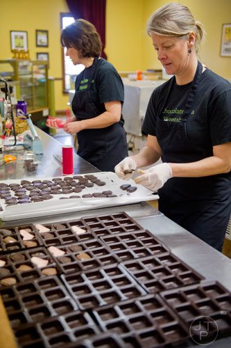 Linda Damiani (right) and Anne Stroer fill customer orders at Chamberlain's Chocolate Factory in Peachtree Corners on Tuesday, February 4, 2014.