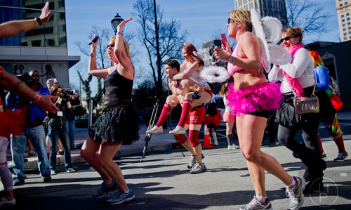 Aaron Yovan (center) carries Achilyse Ann across the finish line during the Cupid Undies Run in Midtown on Saturday, February 15, 2014. 