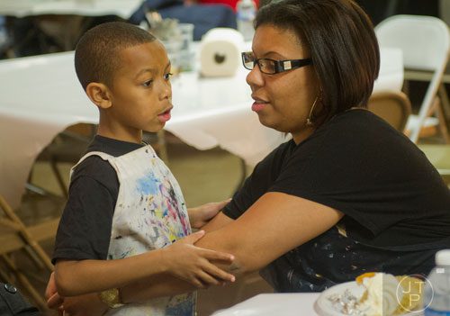 Delilah Keligond (right) ties an apron around her son Donovan Martin's waist during Mother-Son Date Night at Saville Studios in Peachtree City on Saturday, February 15, 2014. 