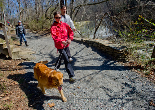 Constantine Voin (right), his wife Marina and Zoya Dats walk the trails at Old Mill Park in Roswell with the Voin's golden retriever Dante on Sunday, February 16, 2014. 