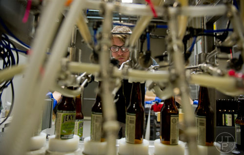 Richard Oakes uses the bottling machine at Jekyll Brewing in Alpharetta on Tuesday, February 18, 2014. 