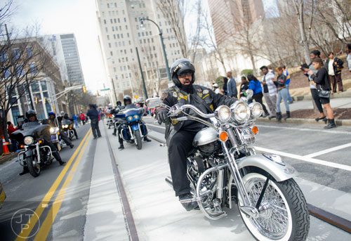 J.P. Moton rides his motorcycle down Auburn Ave. in Atlanta during the Black History Month Parade on Saturday, February 22, 2014. 