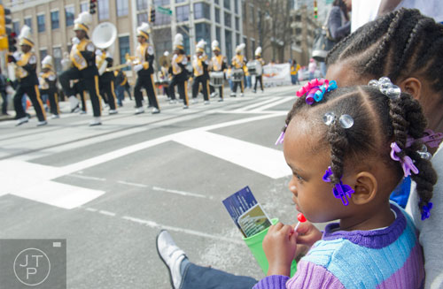 Cyann Faulcon (right) sits with her mother as the Douglas High School marching band make their way down Auburn Ave. in Atlanta during the Black History Month Parade on Saturday, February 22, 2014. 