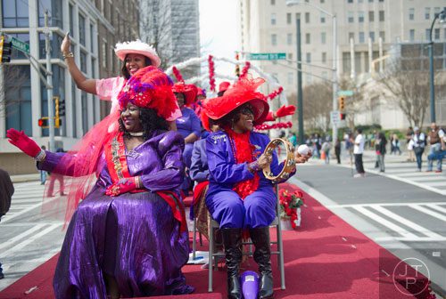 Flo Gaines (left), Arlesa Acholes and JoeAnn Lindsey wave to the crowd as they ride a float down Auburn Ave. in Atlanta during the Black History Month Parade on Saturday, February 22, 2014. 