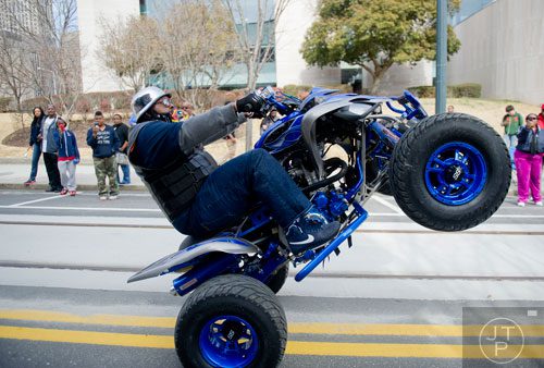 Dre Frazier rides his quad in a wheelie down Auburn Ave. in Atlanta during the Black History Month Parade on Saturday, February 22, 2014. 