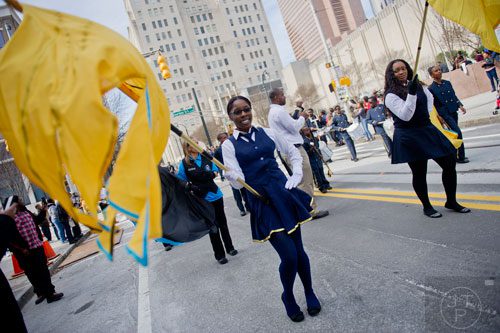 Ashwanna Gordon (center) carries a flag as she marches down Auburn Ave. in Atlanta with the Legends Marching Band from the Bahamas during the Black History Month Parade on Saturday, February 22, 2014. 