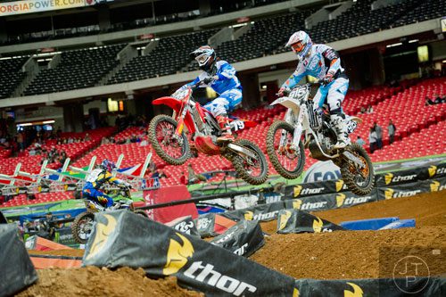 Ryan Zimmer (79) and Adrien Lopes (915) catch some air as they compete in a qualifying round of the Monster Energy AMA Supercross FMI World Championship at the Georgia Dome in Atlanta on Saturday, February 22, 2014.