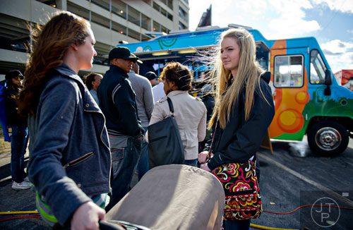 Emily Fayette (right) and her sister Caitlin stand in line to get food at the Yumbii food truck during the second annual Atlanta Taste of The Trucks Festival in a parking lot off of Spring and 8th streets in downtown Atlanta on Saturday, March 29, 2014. 
