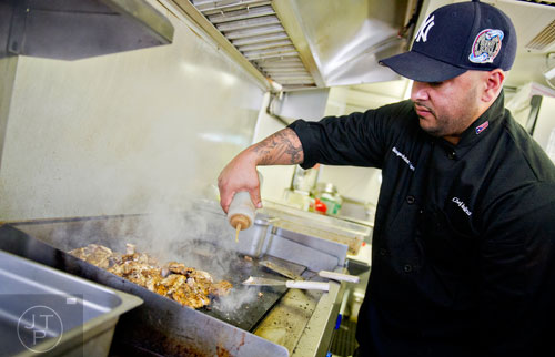 Javier Molina cooks a grill full of chicken inside the Buen Provecha food truck during the second annual Atlanta Taste of The Trucks Festival in a parking lot off of Spring and 8th streets in downtown Atlanta on Saturday, March 29, 2014. 