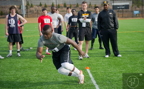 Isidore Sam (right) cuts hard in a pro agility drill during the first tryouts for the new Kennesaw State University football team at The Perch on campus on Saturday, March 22, 2014. 