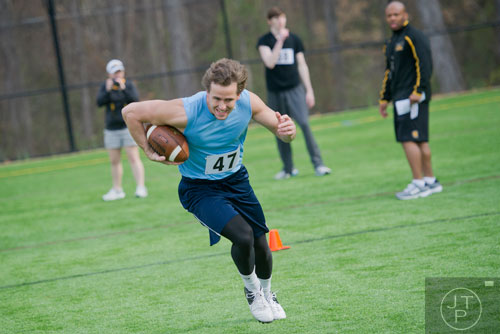 Patrick Jones (center) sprints down the field with the ball in a receiver drill during the first tryouts for the new Kennesaw State University football team at The Perch on campus on Saturday, March 22, 2014. 
