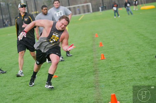 Brett Gillespie (center) runs in a power pull drill during the first tryouts for the new Kennesaw State University football team at The Perch on campus on Saturday, March 22, 2014. 