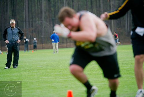 Head coach Brian Bohannon (left) watches drills during the first tryouts for the new Kennesaw State University football team at The Perch on campus on Saturday, March 22, 2014. 