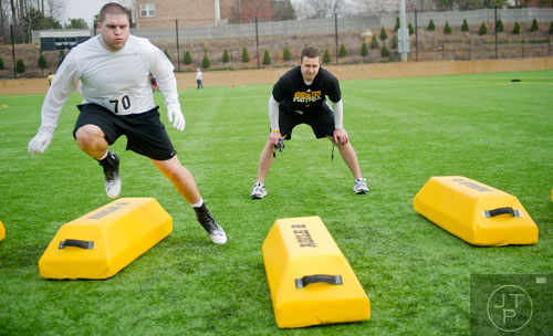 Coach Shane Bowen (right) watches Nick Perrotta (70) run over bags in a linebacker drill during the first tryouts for the new Kennesaw State University football team at The Perch on campus on Saturday, March 22, 2014. 
