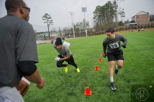 David Rogers (right) and Cameron Bush compete in a sequence drill under the watchful eyes of coach Chris Bland during the first tryouts for the new Kennesaw State University football team at The Perch on campus on Saturday, March 22, 2014. 