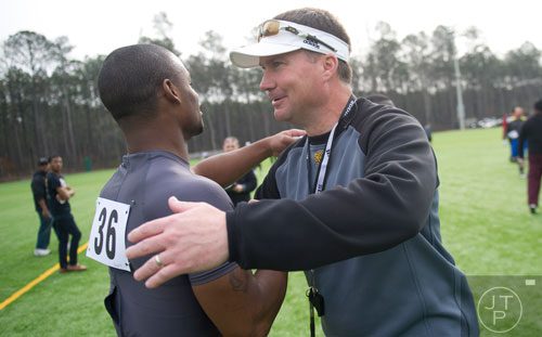 Head coach Brian Bohannon (right) hugs it out with Ryan Godhigh after the first tryouts for the new Kennesaw State University football team at The Perch on campus on Saturday, March 22, 2014. 