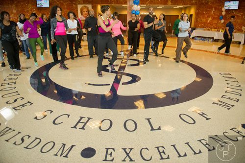 Andrea Riggs (center) leads a workout during Dr. Valerie Montgomery Rice's kickoff for her 12 week challenge to loose 15 inches at the Morehouse School of Medicine in Atlanta on Saturday, March 1, 2014. 