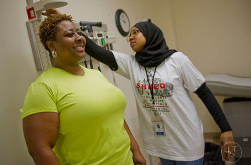 Schauna Gillam (left) has her measurements taken by Halima Garba before starting Dr. Valerie Montgomery Rice's 12 week challenge to lose 15 inches on Saturday, March 1, 2014. 