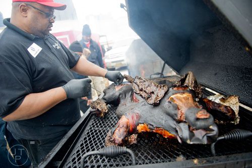 Wade McSwain checks the temperature on his whole hog during the Beer, Bourbon & BBQ Festival at Atlantic Station in Atlanta on Saturday, March 1, 2014. 