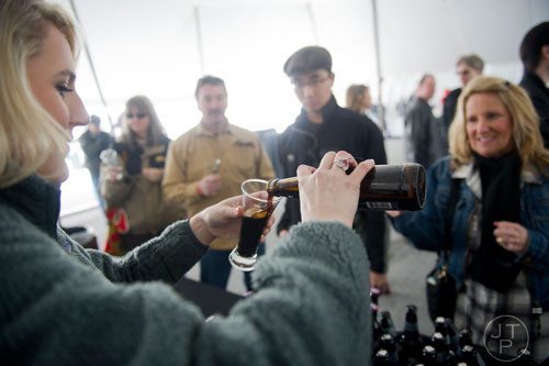 Addy Steigerwalt (left) pours a glass of beer during the Beer, Bourbon & BBQ Festival at Atlantic Station in Atlanta on Saturday, March 1, 2014. 