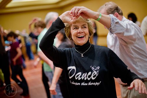 Sharon Parrott (center) learns the cha cha with partner Mark Padolsky during the Peach State Dance Festival at the Crown Plaza Ravinia hotel in Atlanta on Saturday, March 22, 2014. 