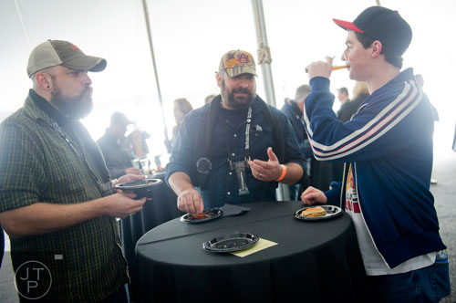 Andrew Payne (right) takes a sip of beer as he talks with Matt Zatezalo and Mike Fetter during the Beer, Bourbon & BBQ Festival at Atlantic Station in Atlanta on Saturday, March 1, 2014. 