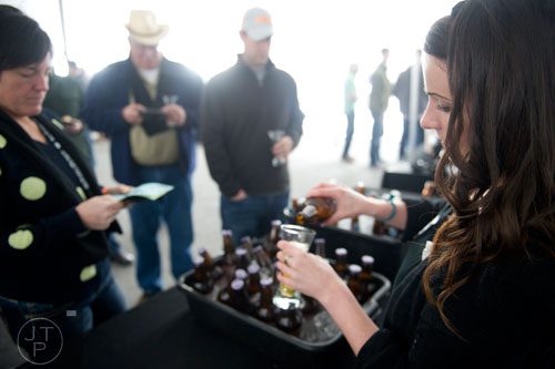 Samantha Giglio (right) pours a glass of beer during the Beer, Bourbon & BBQ Festival at Atlantic Station in Atlanta on Saturday, March 1, 2014.