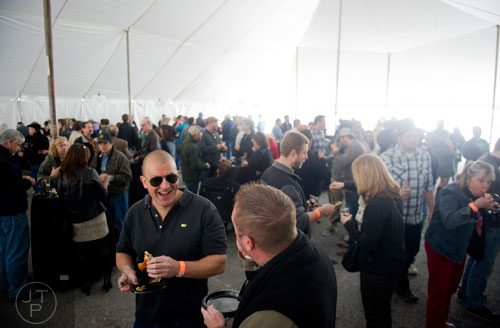 Chris Staub (center) smiles as he tastes a plate of barbeque during the Beer, Bourbon & BBQ Festival at Atlantic Station in Atlanta on Saturday, March 1, 2014. 
