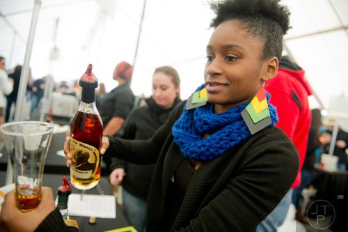 A woman pours a glass of bourbon during the Beer, Bourbon & BBQ Festival at Atlantic Station in Atlanta on Saturday, March 1, 2014. 