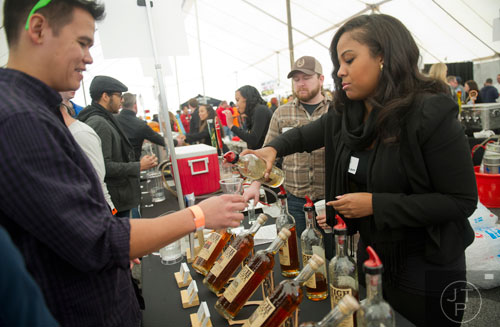 Kaela Hardy (right) pours a glass of bourbon for Chris McBrayer during the Beer, Bourbon & BBQ Festival at Atlantic Station in Atlanta on Saturday, March 1, 2014. 