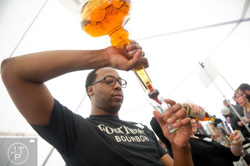 Vincent Leggett pours a glass of bourbon during the Beer, Bourbon & BBQ Festival at Atlantic Station in Atlanta on Saturday, March 1, 2014. 