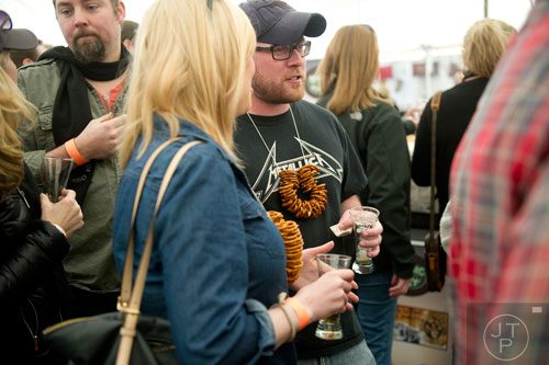 James Burnett (center) talks with Hannah Davis as they stand in line to taste some of the numerous bourbon stations during the Beer, Bourbon & BBQ Festival at Atlantic Station in Atlanta on Saturday, March 1, 2014. 