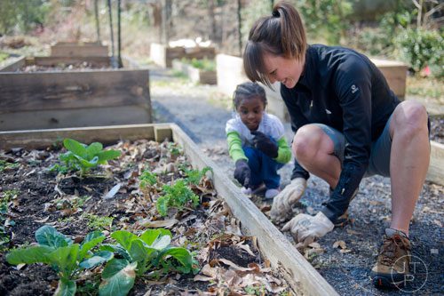 Kat Roberts (right) and Sanai Odro remove weeds from one of the garden beds at the Cator Woolford Gardens at the Frazer Center in Atlanta on Sunday, March 2, 2014.
