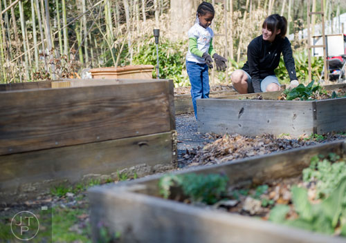 Sanai Odro (left) and Kat Roberts remove weeds from one of the garden beds at the Cator Woolford Gardens at the Frazer Center in Atlanta on Sunday, March 2, 2014.