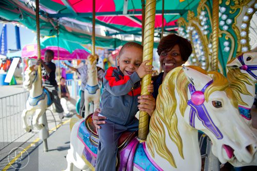 Jonah Isler (center) rides the merry-go-round with his mother Tanja during the Atlanta Fair at Turner Field on Saturday, March 8, 2014. 