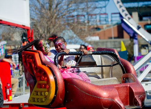 Jada Hill (left) rides the Sizzler with Marshae Perry during the Atlanta Fair at Turner Field on Saturday, March 8, 2014. 
