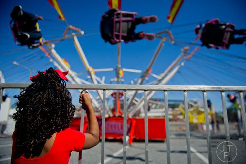 Emani Styles (left) waits for her turn to ride the swings during the Atlanta Fair at Turner Field on Saturday, March 8, 2014. 