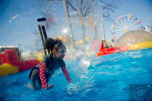 Aaliyah Moodie (left) crawls on water inside an inflatable ball during the Atlanta Fair at Turner Field on Saturday, March 8, 2014. 
