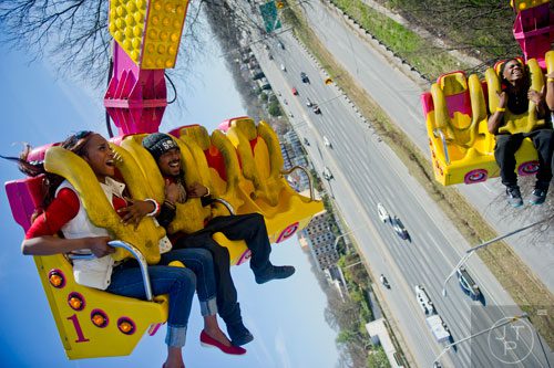 Shawnna Murphy (left) and Tony Berry are flipped upside down as the ride The Claw during the Atlanta Fair at Turner Field on Saturday, March 8, 2014.