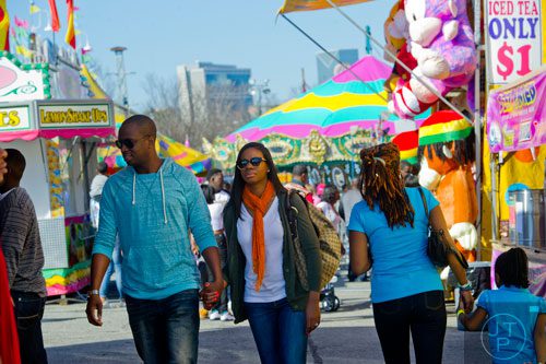 Chris Thomas (left) holds hands with his wife Cherie as they walk down the midway during the Atlanta Fair at Turner Field on Saturday, March 8, 2014. 