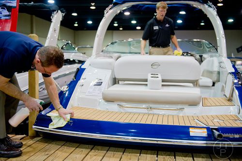 Eddie Marszalek (left) and Paul Williams clean one of the boats on display during the Spring Into Summer Boat Show at the Gwinnett Center in Duluth on Sunday, March 9, 2014.